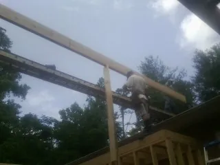 Carpenter setting a ridge beam over a new addition frame — Ice Dam Removal by Roofing Brothers in Sharon Hill