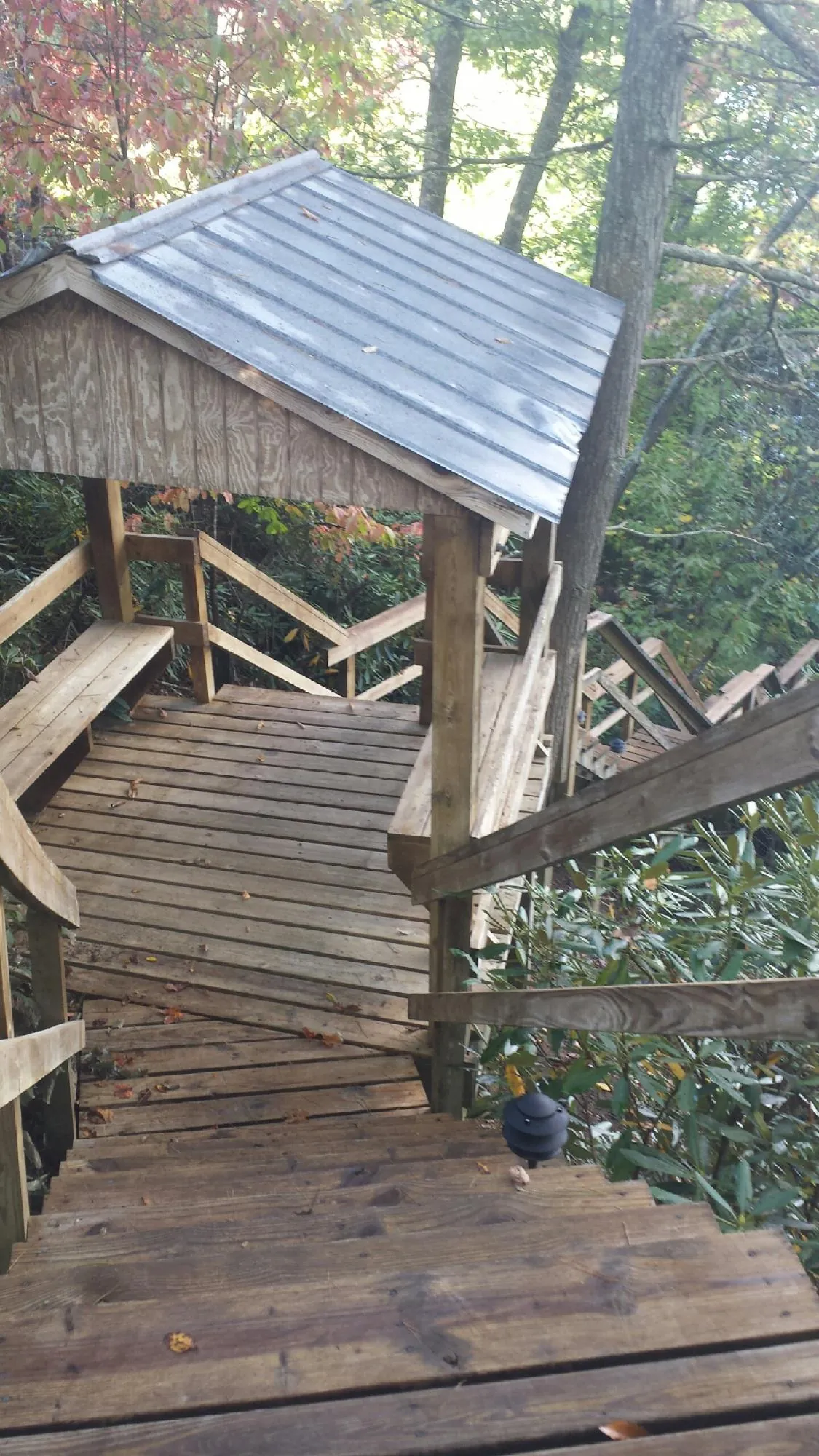Metal roofed shelter over wooden steps on a wooded walkway — Skylight Repair & Installation work by our crew in Sharon Hill