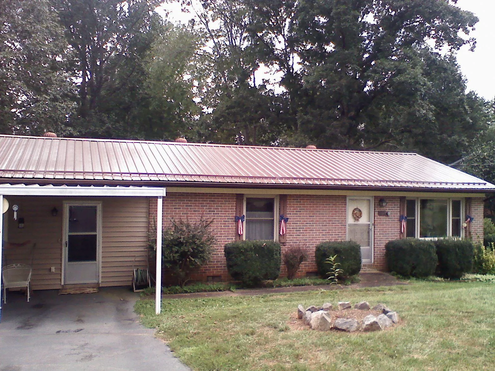 Bronze metal roof and carport on a brick ranch home — Roof Repair work by our crew in Sharon Hill